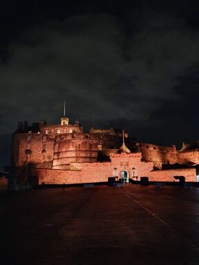 Edinburgh castle lit up spectacularly at night.